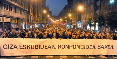 Marchers carry a sign pronouncing "Human rights. Solution. Peace. In Bilbao in January 2014. 